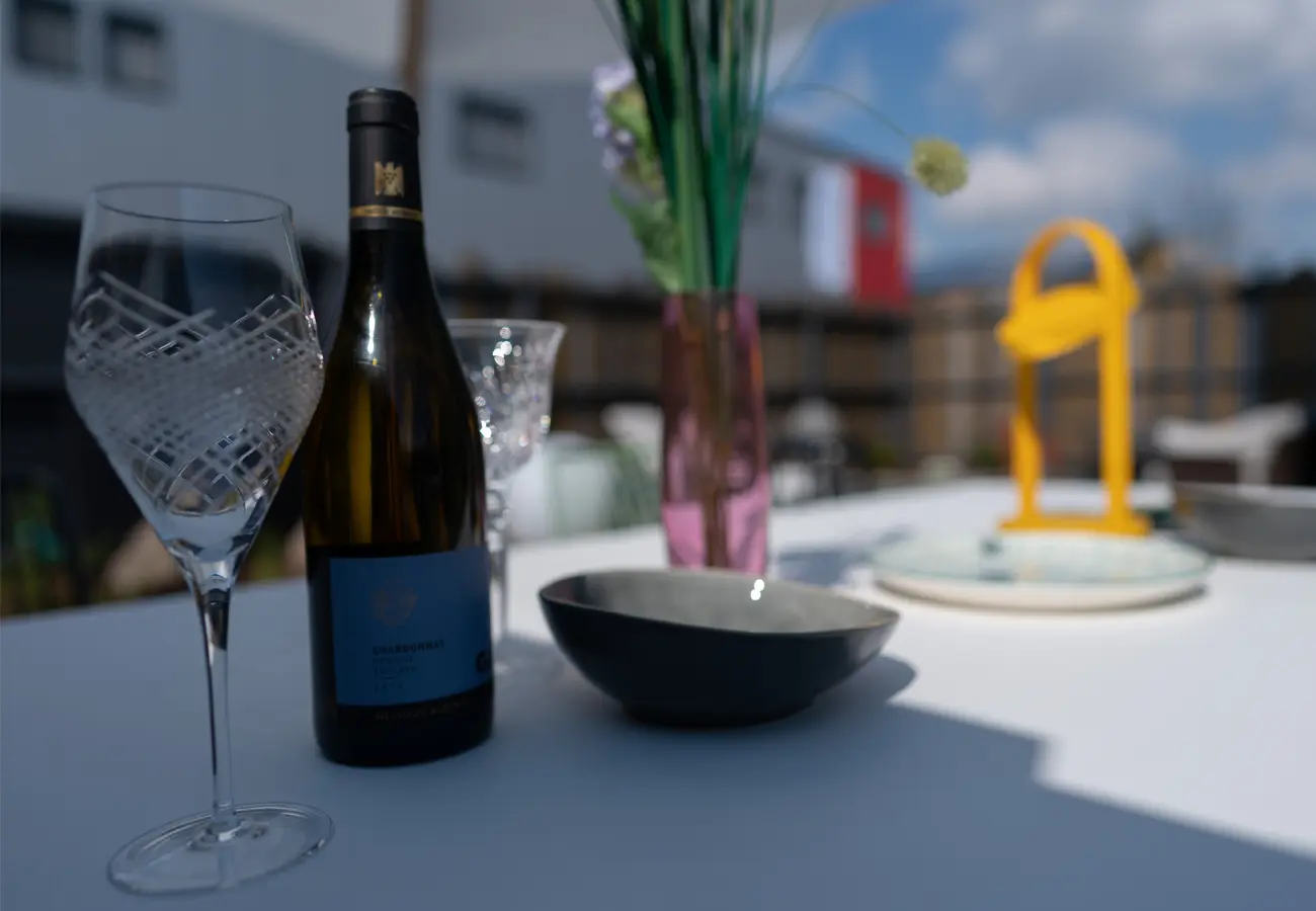 Wein, Gläser und Akkuleuchte auf einem Gartentisch