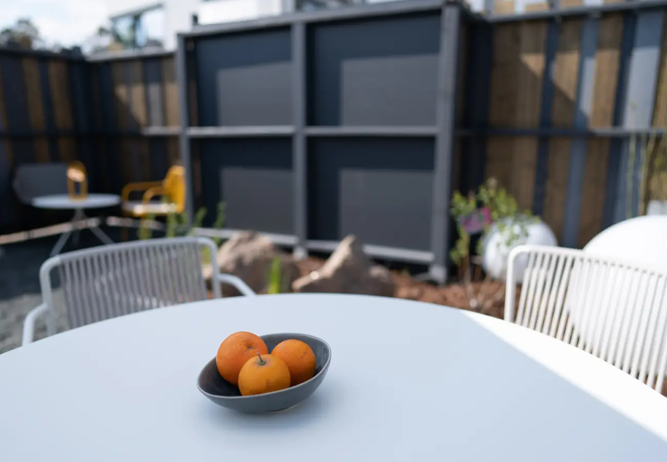 Gedeckter Gartentisch mit einer Schale Orangen