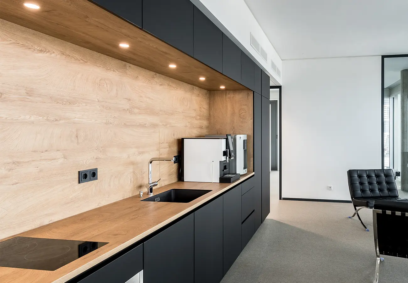 Teeküche mit Rückwand aus Holz und Kaffeemaschine