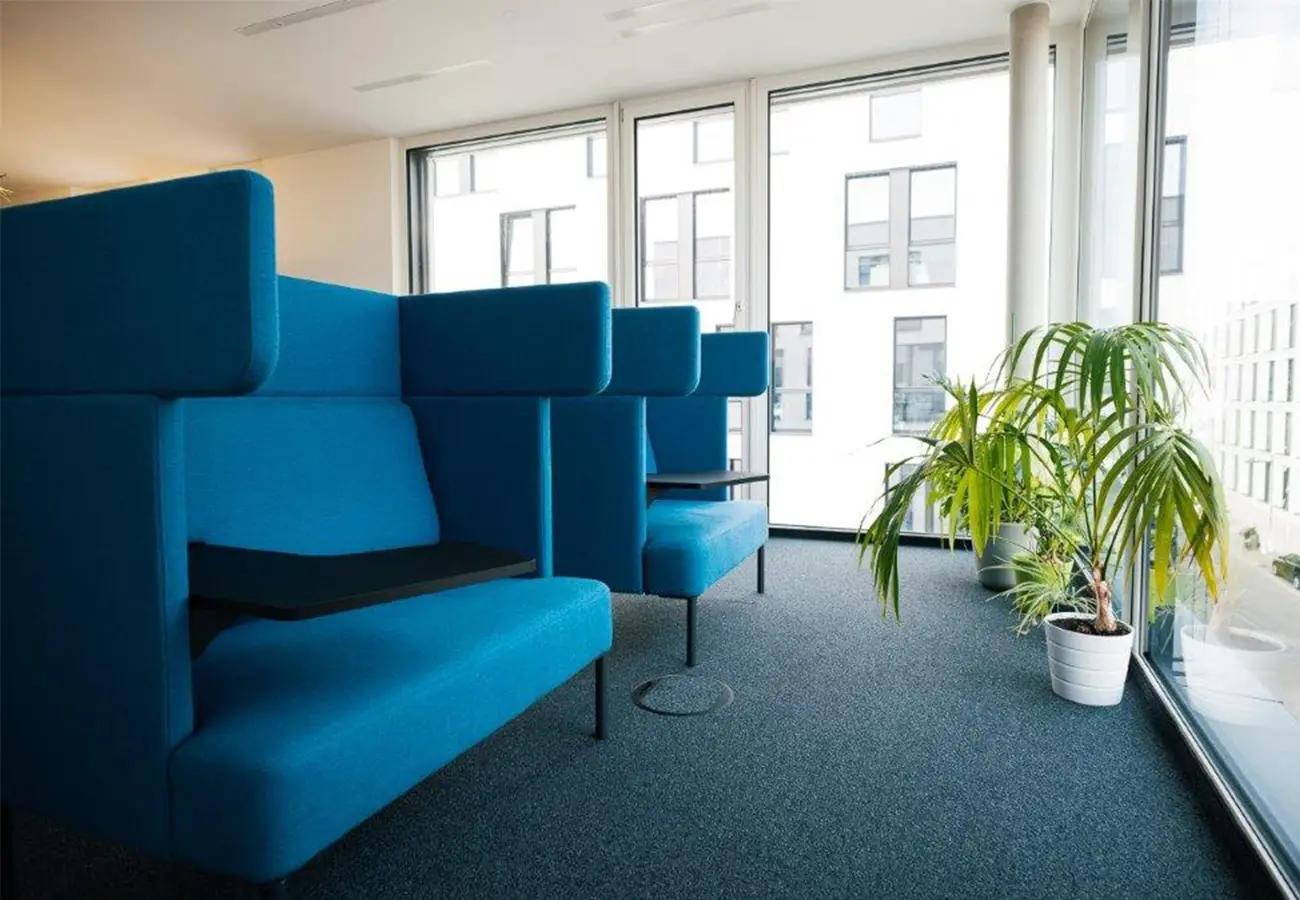 Blaue Sitznischen mit hohen Rückenlehnen am Fenster