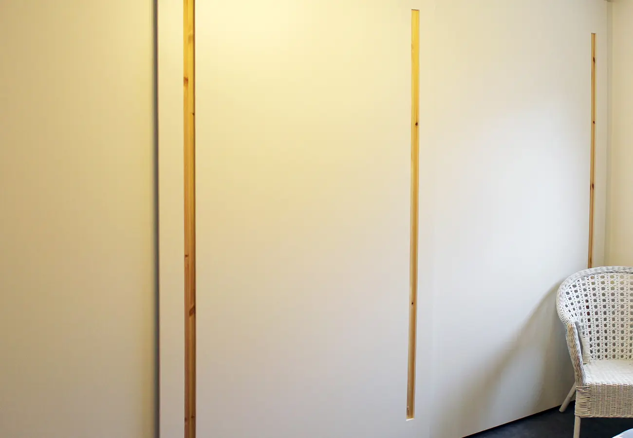 Schiebetürschrank mit schmalen Griffleisten aus Holz