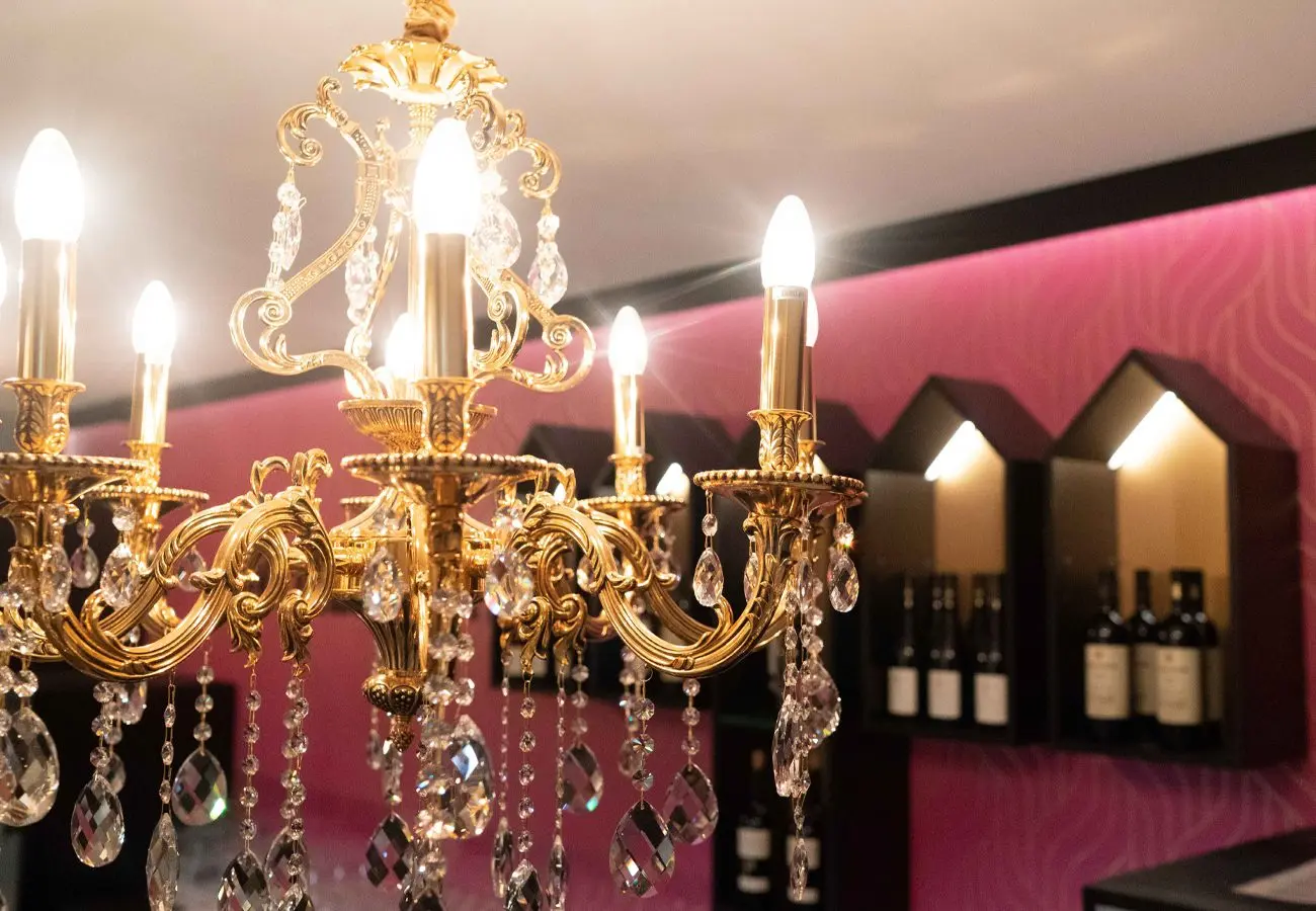 Kronleuchter vor der pinkfarbenen Wand des Saals