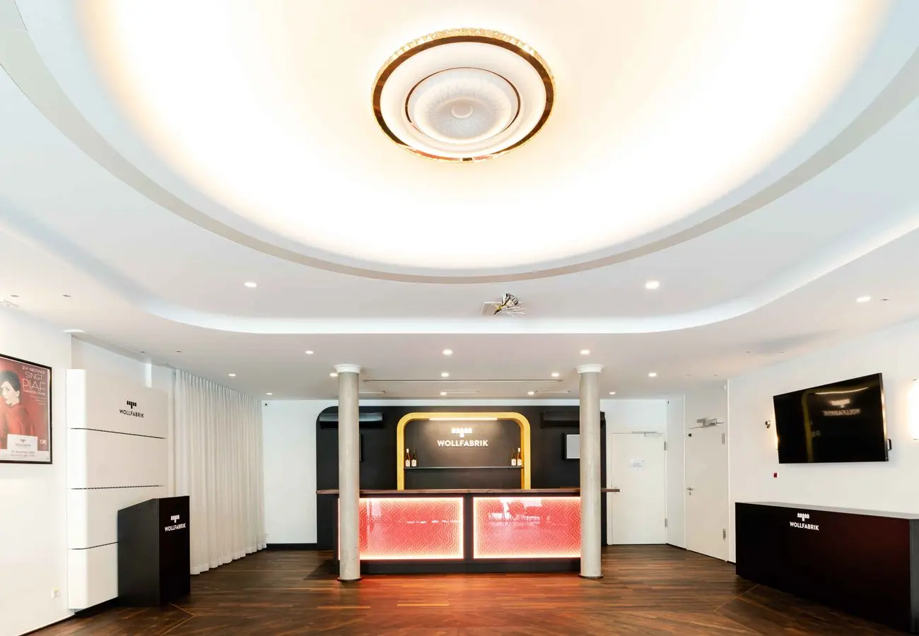 Foyer mit Stuckdecke und kleiner beleuchteter Theke